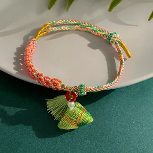 Close-up of handmade woven bracelet with five-color rope and zongzi tassel pendant