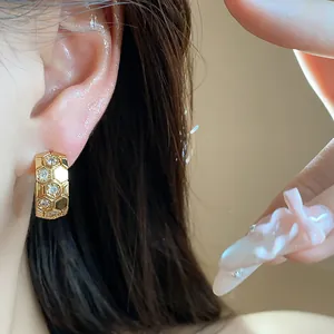 Close-up view of elegant 18k gold-plated honeycomb C-shaped hoop earrings with zircon insets