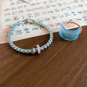 Close-up detail of retro light blue resin Fu character ring and woven bracelet jewelry set