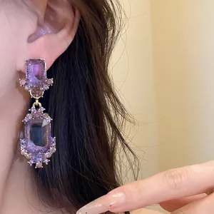 Vintage oorbellen in paleisstijl met paarse rechthoekige edelstenen en kristallendetails.