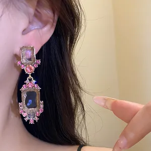 Macro detail van vintage geometrische oorbellen met roze en grijze strass steentjes