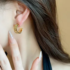 Detailed view of gold-plated C-shaped earring featuring a zircon-set honeycomb pattern