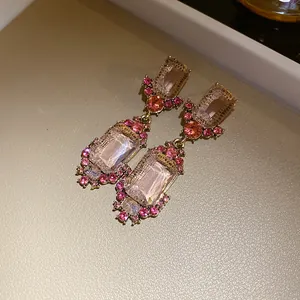 Detail van vintage paleisstijl oorbellen met roze rechthoekige edelstenen