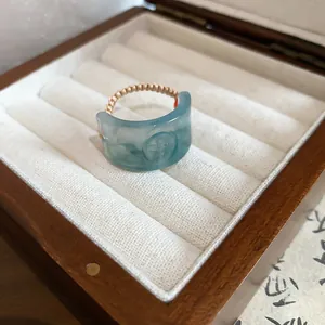 Macro view of light blue resin ring with 'Fu' engraving and elegant woven band