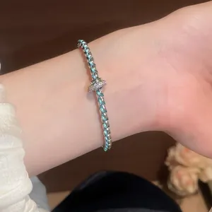 Detailed view of an elegant braided resin bracelet with silver accents worn on a wrist