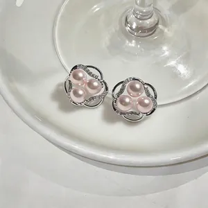 Elegant flower-shaped silver stud earrings featuring pink pearls and sparkling cubic zirconia