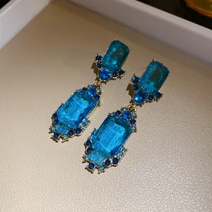 Gedetailleerde macro-opname van vintage blauwe kristallen oorbellen met koninklijk design
