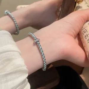 Close-up of New Chinese style braided bracelet with teal resin and silver link details