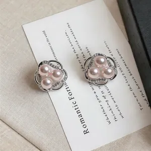 Detailed close-up of elegant floral hollow stud earrings with pink pearls and zircon stones.