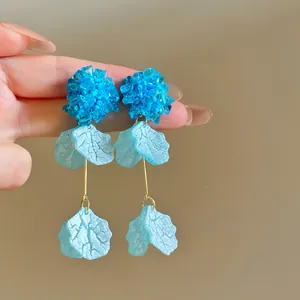 Detailed view of elegant blue crystal flower earrings featuring dangling textured petals
