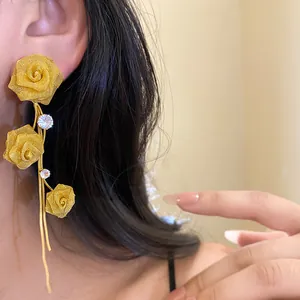 Elegante goldene Rosen-Ohrringe mit glitzernden Zirkonia-Details an einem Model