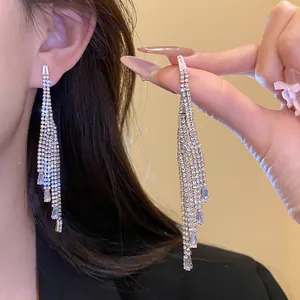 Close-up detail of elegant silver tassel earrings with sparkling white zirconia stones.