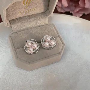 Detailed close-up of pink pearl flower stud earrings with shimmering zircon accents