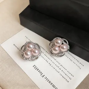 Close-up of elegant floral design earrings with pink pearls and sparkling zircons