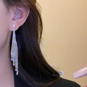 Elegant close-up shot of sparkling zircon rhinestone long tassel earrings worn on ear