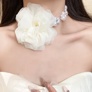 Vista dettagliata di un'elegante collana con un grande fiore in chiffon bianco e perle.