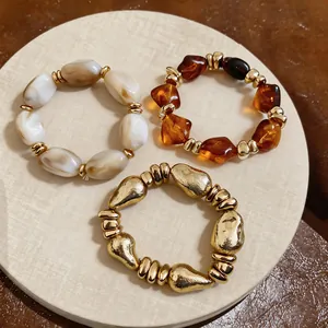 Nahaufnahme von drei elastischen Retro-Armbändern mit unregelmäßigen geometrischen Perlen.