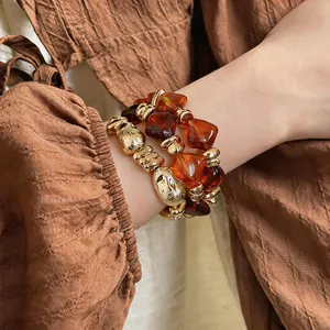 Detail eines elastischen Vintage-Armbands mit bernsteinfarbenen und goldenen Perlen