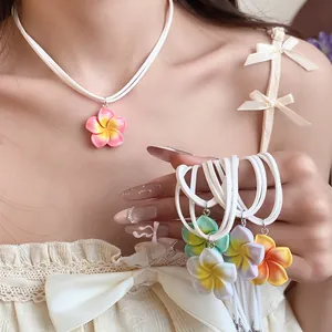 Detailweergave van kleurrijke frangipani bloem hanger kettingen in Hawaiiaanse vakantiestijl.