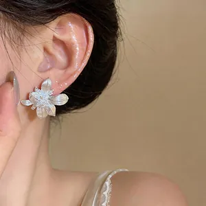 Primer plano de pendientes de flor de plata retro franceses con detalles de circón