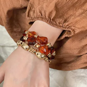 Nahaufnahme des Vintage-Armbands aus bernsteinfarbenem Harz mit goldenen Akzenten