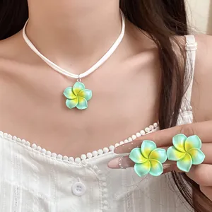 Detailweergave van de Hawaiiaanse mintgroene en gele plumeria bloem sieradenset