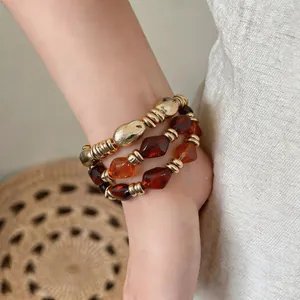Detailaufnahme eines Vintage-Armbands mit bernsteinfarbenen und goldenen Schmuckperlen