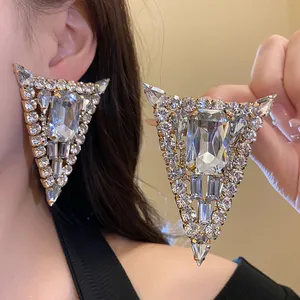 Primer plano de pendientes triangulares de diamantes de imitación con detalles brillantes.