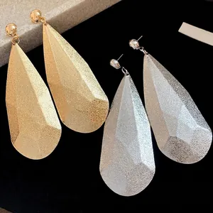 Grandi orecchini geometrici a goccia in metallo con finitura lucida oro e argento