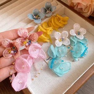 Detailed view of handmade chiffon flower tassel earrings in vibrant pastel colors