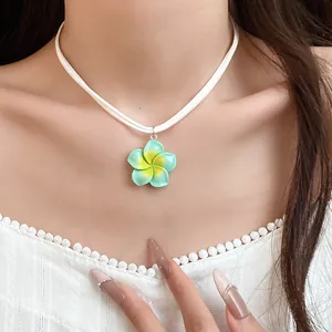 Close-up van een schattige Hawaiiaanse ketting met blauw en gele plumeria bloem hanger
