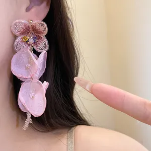 Close-up shot of pink chiffon flower tassel earrings with delicate embroidery details
