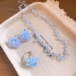 Vista dettagliata di un set di gioielli a forma di uva con collana, anello e orecchini.