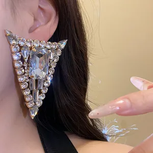 Detalle de un lujoso pendiente triangular con cristales transparentes multi-corte