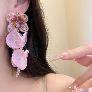 Detailed close-up view of pink chiffon flower tassel earrings with embroidered bead accents