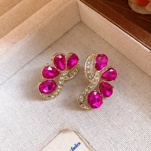 Exquisite close-up detail of vintage fuchsia gemstone earrings with gold floral setting
