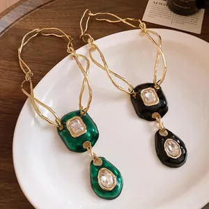 Detailed view of vintage twisted chain necklaces with green and black pleated rhinestone pendants