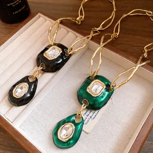 Close-up of vintage twisted gold chain necklaces featuring oval crystal pendants in a box