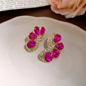 Elegant vintage-style pink gemstone stud earrings with crystal accents in gold finish