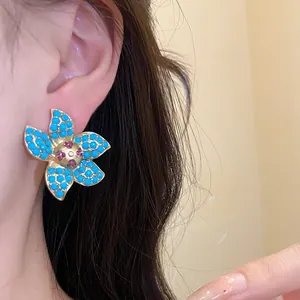 Detailed close-up view of vintage flower stud earrings with turquoise beads and gold finish