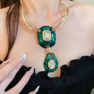 Detailed close-up of a vintage emerald green crystal pendant on a gold twisted chain necklace