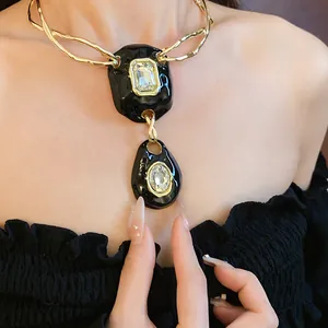Close-up of a vintage black wrinkled pendant necklace with clear crystal inlay.