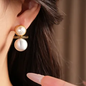 Detail view of gold-plated brushed pearl stud earrings with elegant double pearl design