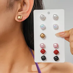 Detailed view of twelve-piece square stud earring set in various colors and metallic finishes
