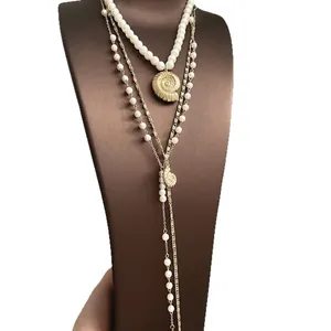 Elegant layered faux pearl long necklace with golden shell pendant on display stand
