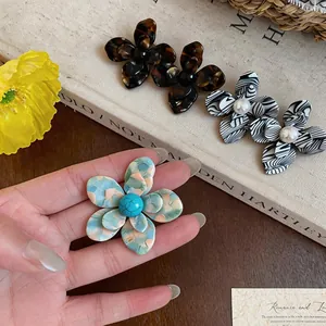 Dettaglio ravvicinato di orecchini vintage a fiore in resina con varie trame molto diverse