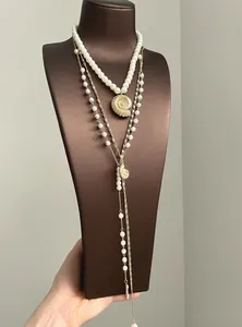 Detail view of layered conch pearl necklace set with elegant gold-tone chain strands
