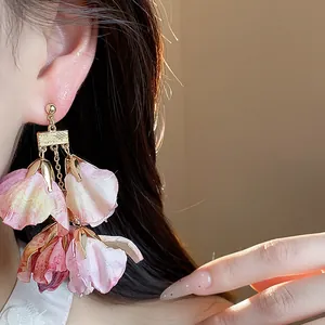 Detailansicht der mehrschichtigen rosa Stoffblütenblätter an Goldohrringen