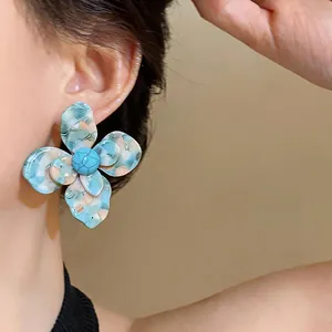 Dettaglio di un orecchino a fiore in resina retrò con petali blu testurizzati
