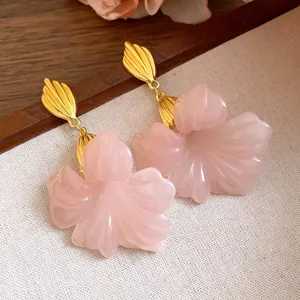 Detailed view of elegant pink resin flower earrings with gold-tone leaf posts